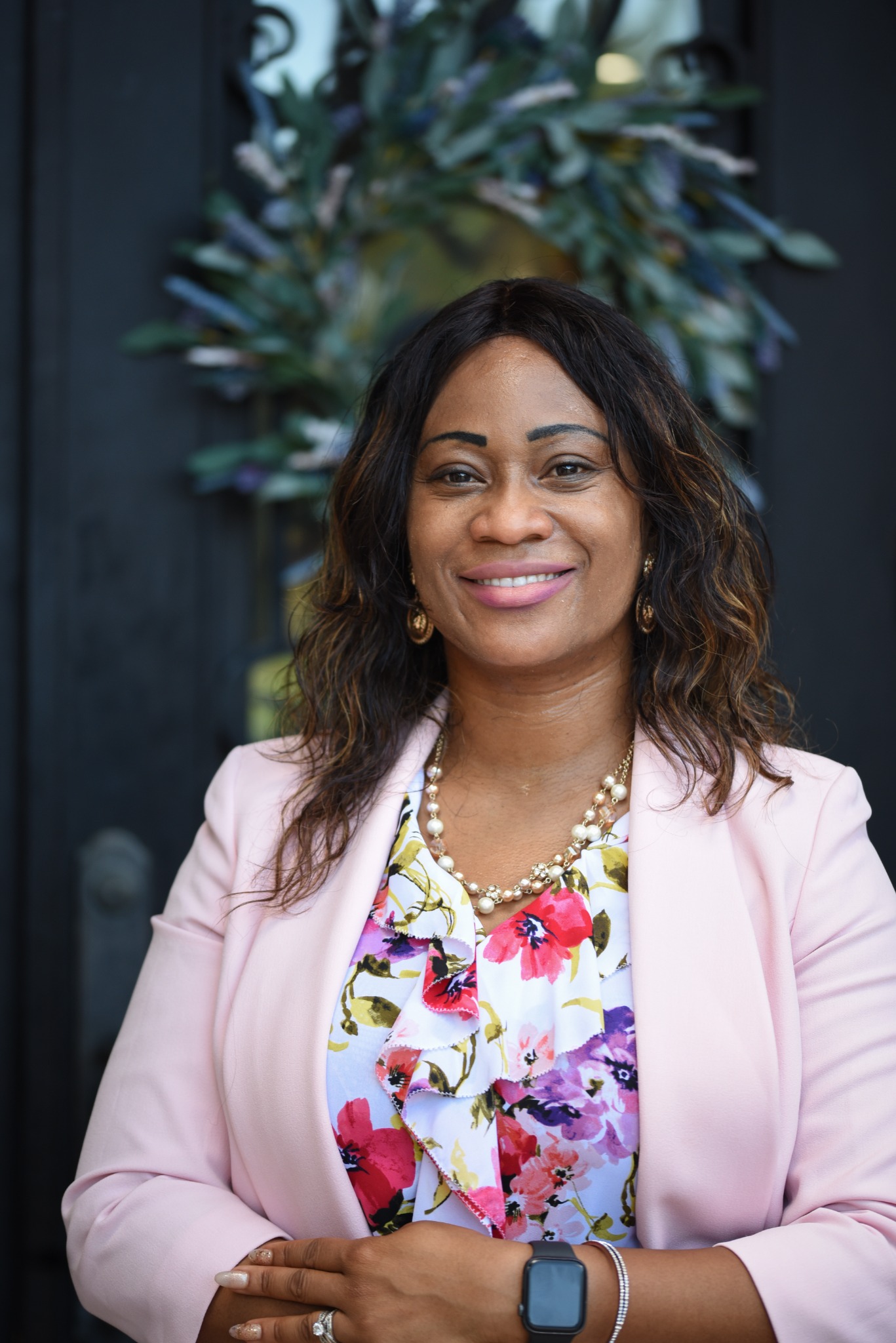 Dr. Claudia Coker smiling in a soft pink blazer
